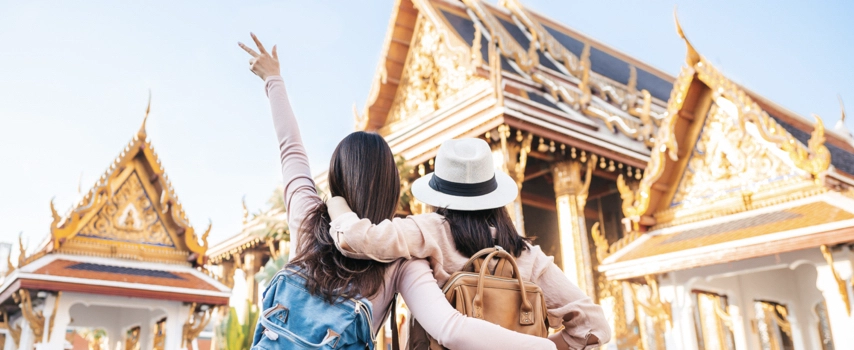 Two women with annual multi trip travel insurance at a temple in Thailand